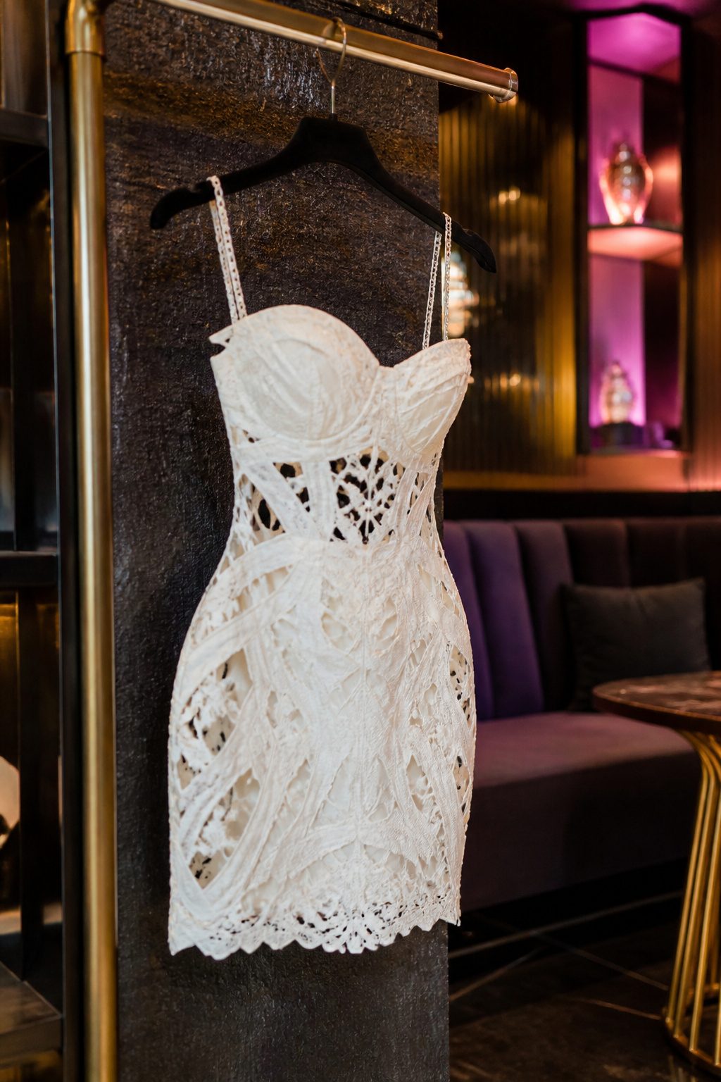 A close-up of a White Cut Out Lace Mini Dress on a hanger.