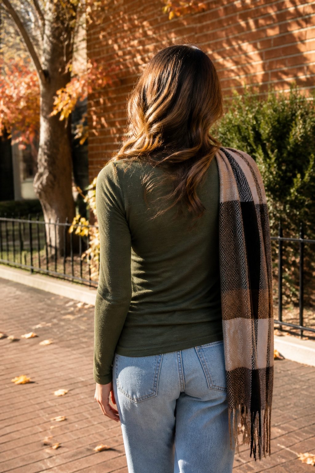 16 Fall Outfit Ideas to Build Your 2026 Wardrobe 1 Model in an olive green long-sleeve tee stands on a city street.