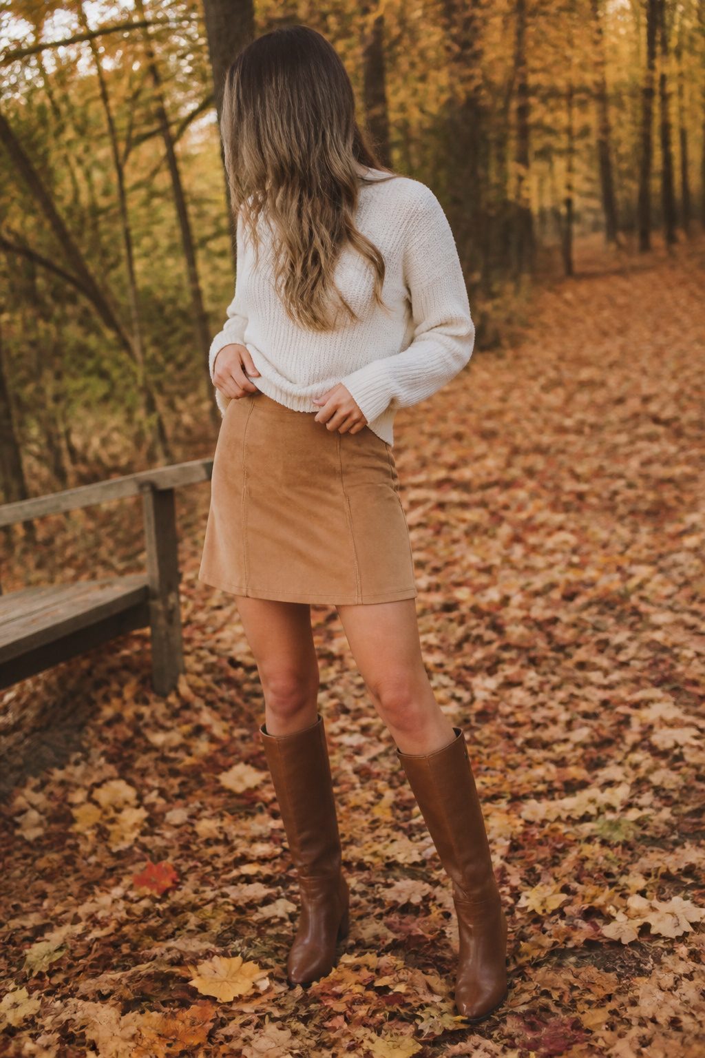 10 Fall Skirt Outfit Ideas for 2026 5 Model wearing a suede skirt and chunky sweater in autumn.