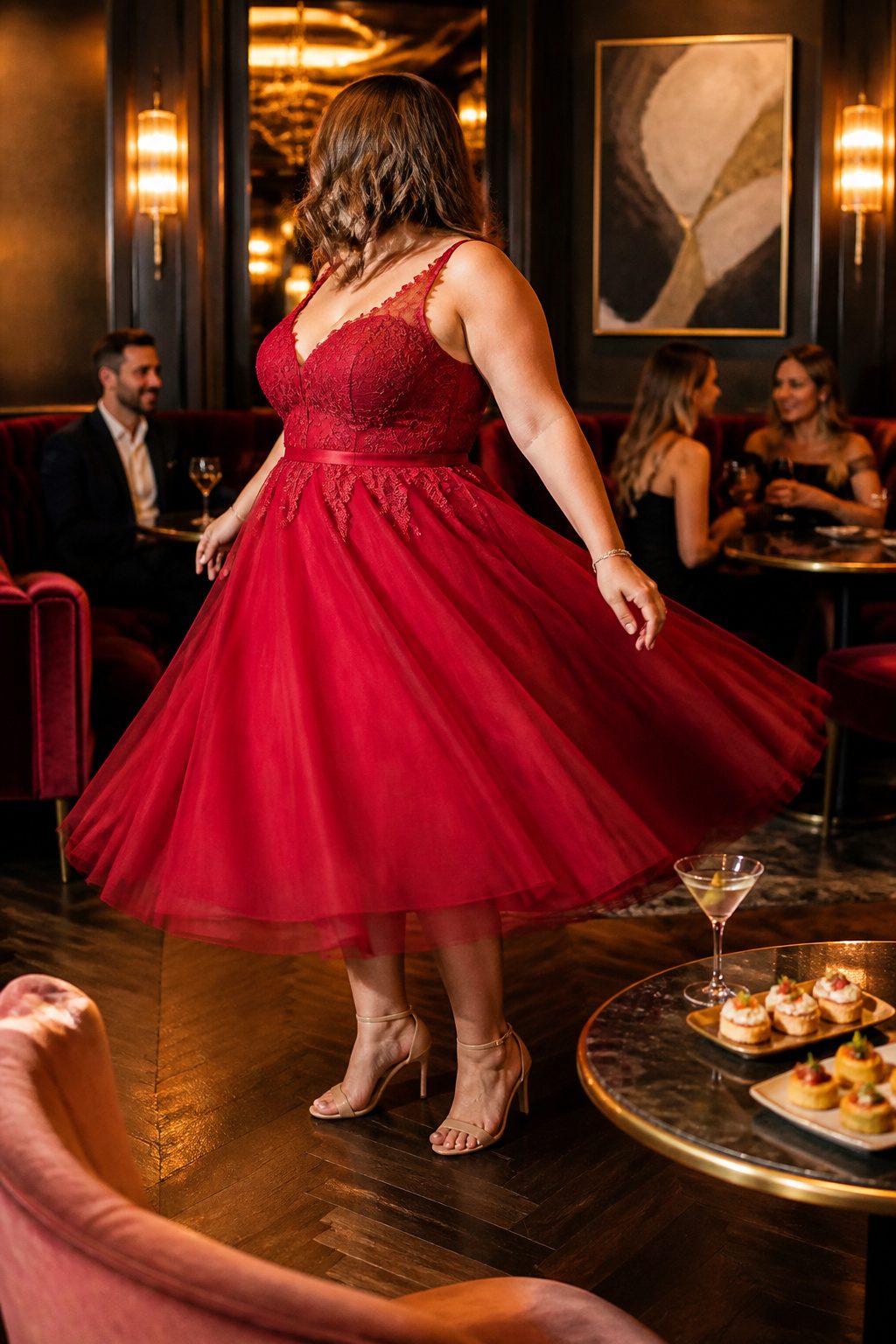 A model twirling in a plus size fit and flare cocktail dress made of red tulle.