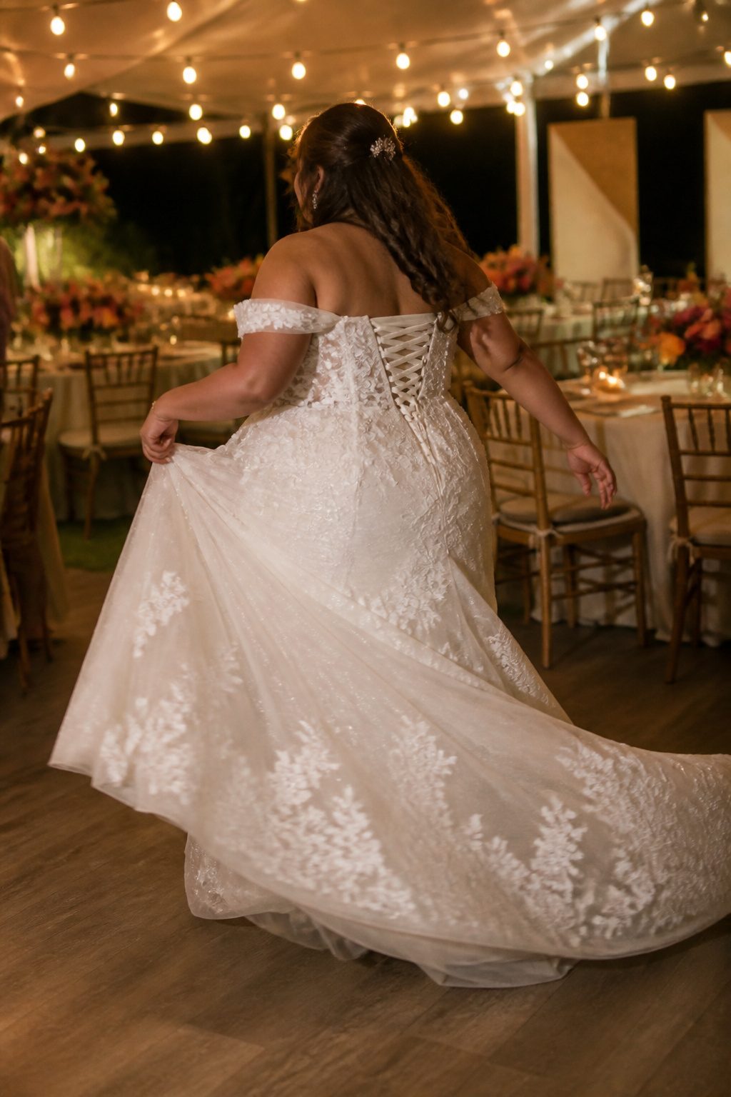 Plus Size Wedding Dress Styles: A-Line to Mermaid 8 A plus-size bride dancing in a wedding dress at a reception.