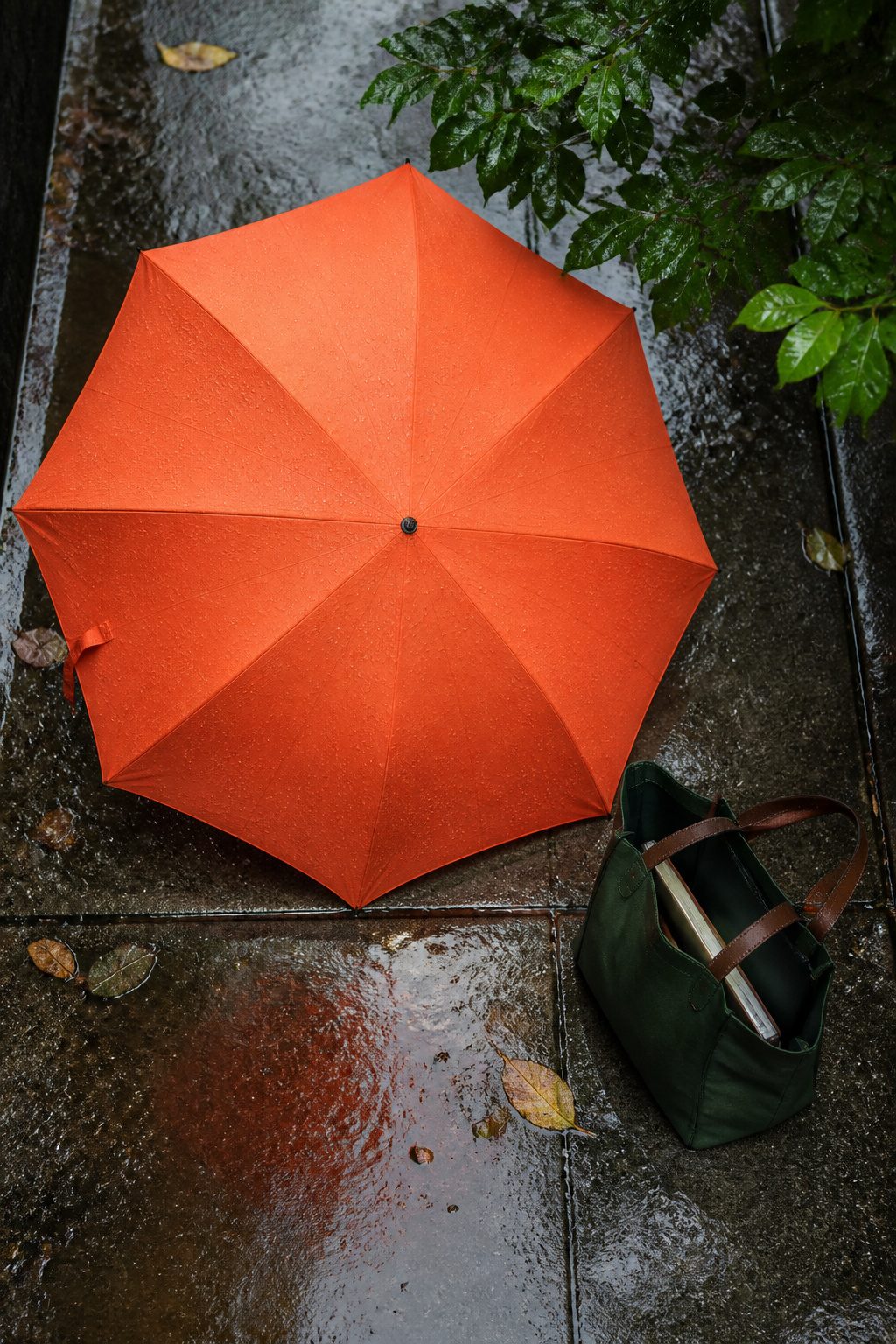 6 Rainy Day Outfit Ideas for Dry, Easy Style in 2026 4 A bright Davek Elite umbrella in a water-resistant canvas tote.