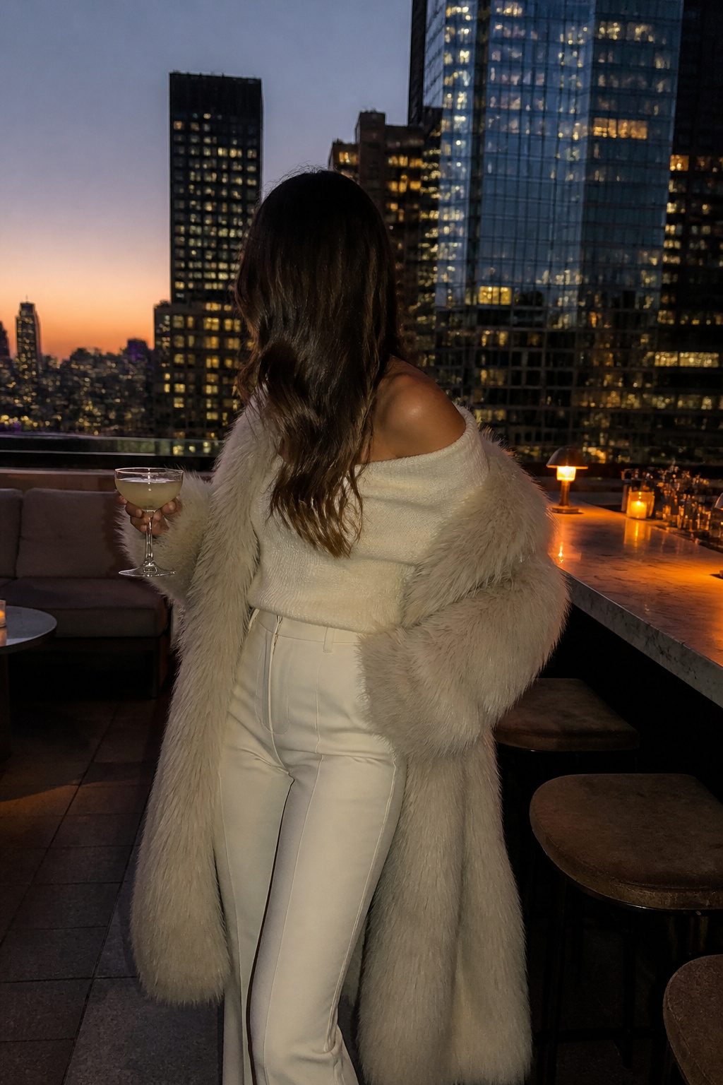 27 Winter Outfit Ideas for Women: 2026 Style Guide 14 Woman in an off-the-shoulder sweater and faux fur coat.