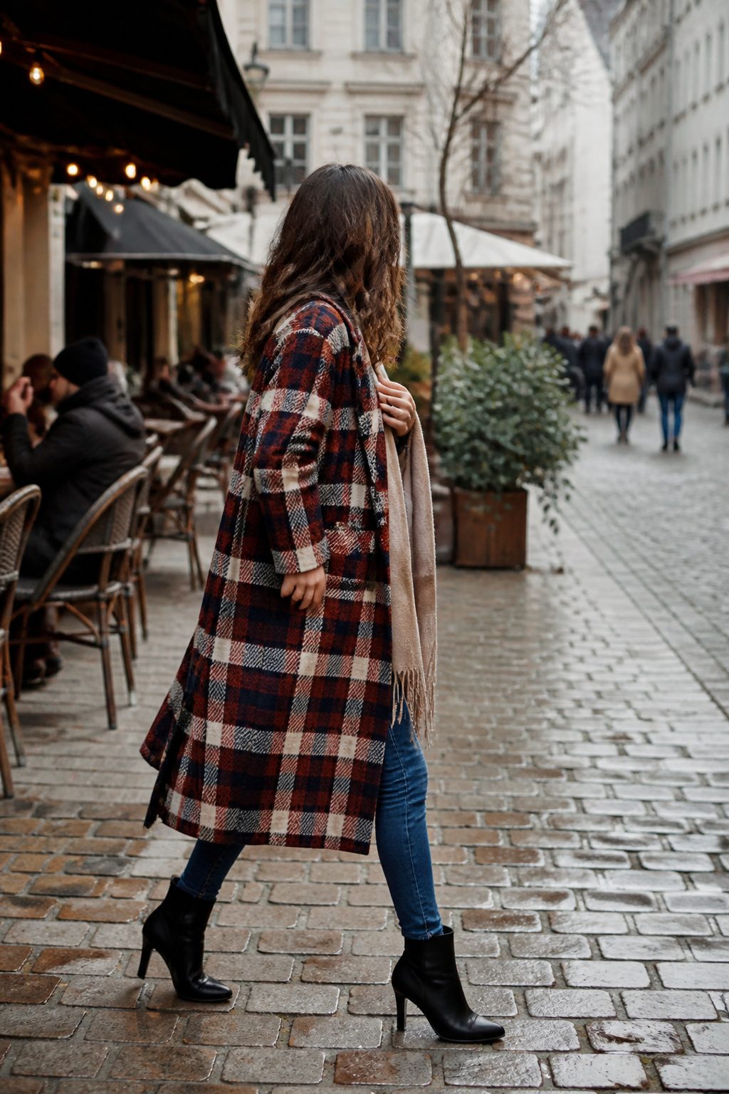 27 Winter Outfit Ideas for Women: 2026 Style Guide 6 Woman in a plaid statement coat and slim jeans in a city square.