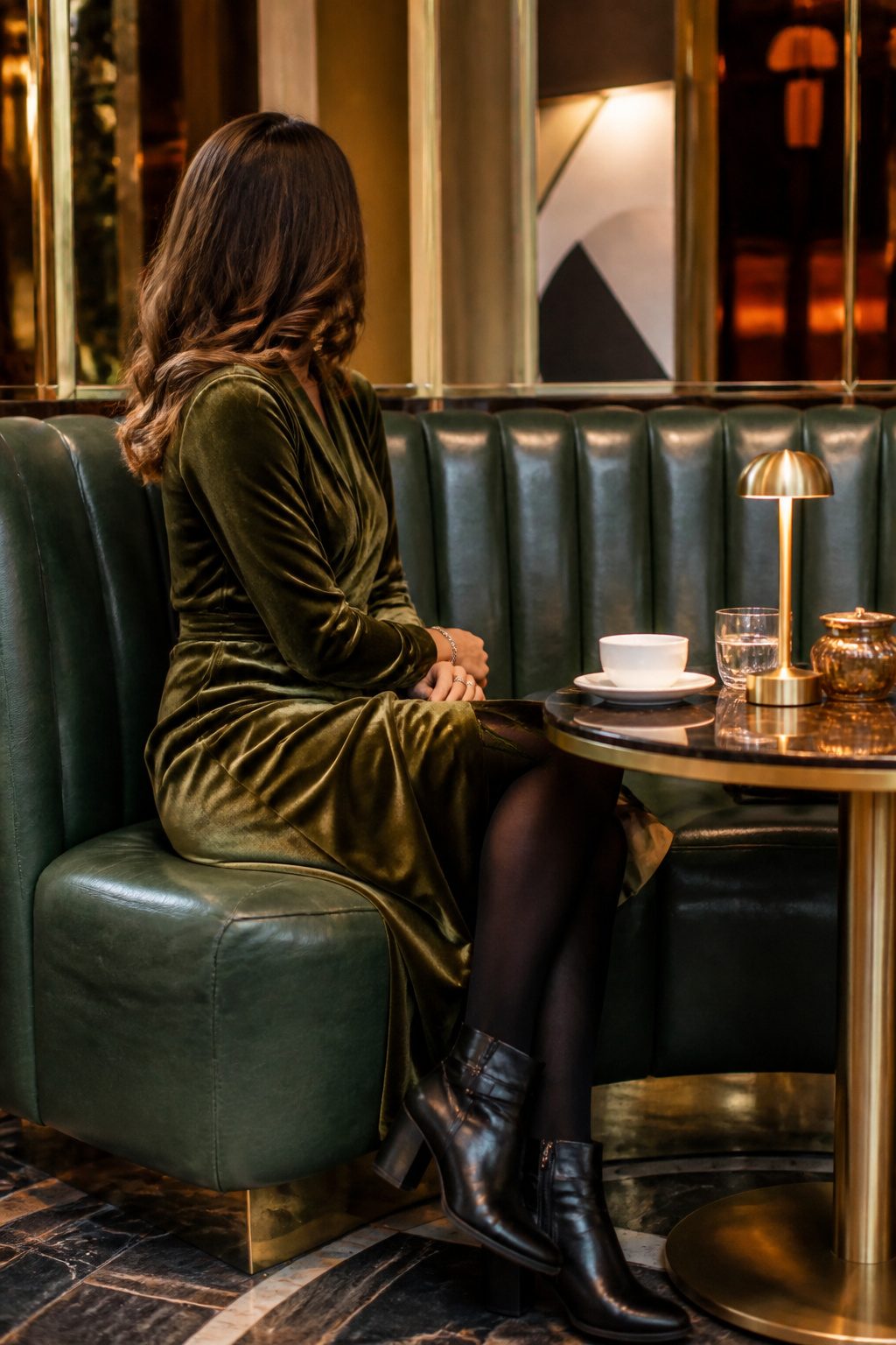 27 Winter Outfit Ideas for Women: 2026 Style Guide 9 Woman in a velvet dress sitting in a café.